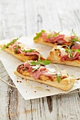 Puff pastry sticks topped with ham and rocket