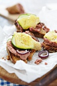 Toasted bread topped with liver pate, cucumber and cheese