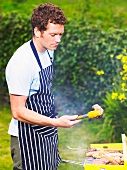 Man inspecting lamb chop at barbecue
