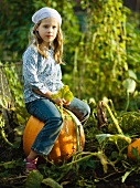 Young girl sitting on a pumpkin