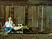 Paar ruht sich aus auf Bank vor Holzschuppen im Garten