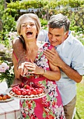 man tries to steal strawberry of tart.