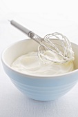 Whisk in a bowl with whipped cream