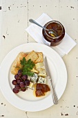 A plate of cheese with crackers, grapes and tsamma melon jam (South Africa)