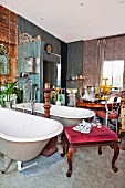 Twin freestanding bathtubs with standpipe tap fittings and various antique furnishings in crammed lounge-style bathroom