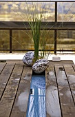Wooden platform on a terrace decorated with aquatic plants and stones