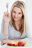 Smiling woman eating plate of food