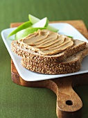 Peanut Butter on a Slice of Whole Wheat Bread;Sliced Apples