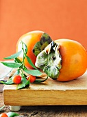 Two Persimmons on a Cutting Board