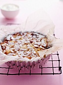 A whole pear and almond tart in a baking dish