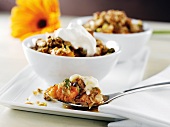 Spoonful of Apricot and Pistachio Crisp with Bowls of Crisp in Background