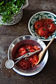 A bowl of peeled tomatoes with a food mill