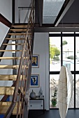 Eine Stahltreppe mit Holzstufen im Fabrikstil führt vom Wohnzimmer mit großer Fensterfront auf die Galerie