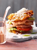 A hash brown burger with mayonnaise, tomatoes and lettuce