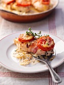 Chicken breast wrapped in bacon with tomatoes and thyme