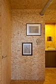 Wohnraum mit Spanplattenausbau und Blick durch offenen Durchgang auf Waschtisch