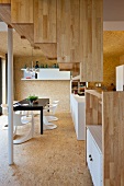 Treppe mit Holzverkleidung in offenem Wohnraum mit modernem Essplatz
