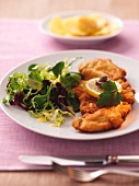 Viennese Schnitzel with lemon slices and a mixed leaf salad