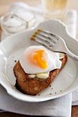 Poached egg on a slice of buttered bread