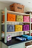 Colourful storage baskets with handles on shelves on top of country-house-style base cabinet