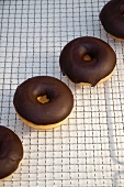 Chocolate-glazed doughnuts on a wire rack