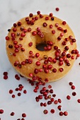A doughnut decorated with pink peppercorns