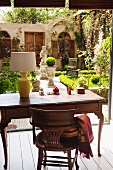 View from a wooden writing desk of a courtyard with an urn and sculptures