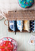Pillow madness - ethnic cushion next to a basket with pillows on a striped surface