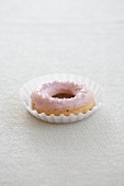 A doughnut with pink icing sugar