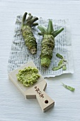 Wasabi root on a piece of newspaper with a whale skin grater (Japan)