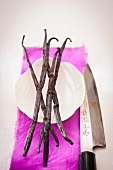 Vanilla pods on a dish with a knife