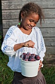 A girl with freshly picked damsons
