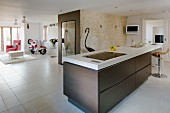 Kitchen island with brown base cabinet in open-plan kitchen