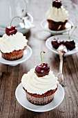 Chocolate muffins with cream and cherries