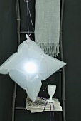 An inflated plastic bag functions as a home-made lampshade for an unusual pendant lamp