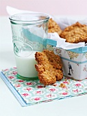 Oat and honey biscuits in a biscuit in with a glass of milk