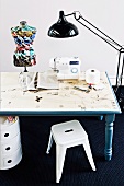 DIY, blue wooden table - table top decorated with adhesive paper with a sewing theme; on top a sewing machine a colorful mannequin