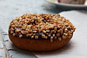 Chocolate Frosted Doughnut Topped with Chopped Nuts