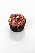 A chocolate cupcake decorated with chocolate beans