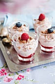 A dessert made with cream cheese, biscuits, raspberries and blueberries