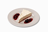 A slice of cheese cake with berry sauce