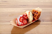 Vanilla ice cream with strawberries and a waffle
