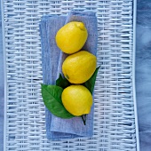 Drei Zitronen auf blauem Tuch