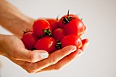 A woman holding fresh tomatoes