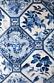 Blue and white bed linen with Chinese-style geometric pattern of flowers, trees and dragons