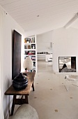 Rustikaler Holztisch an Wand und Kamin in Raumteiler eines offenen Wohnzimmers
