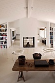 Rustikaler Couchtisch aus Holz und Klassiker Stühle in schlichtem Wohnraum mit weisser Holzdecke