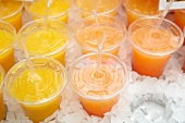 Cups of juice with lids and straws