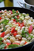 White beans with celery and pepper in a pan