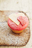 A cupcake decorated with hearts